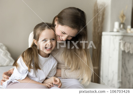 Joyful young mother playing with toddler child on bed Joyful young mother playing with toddler child on bed 106703426