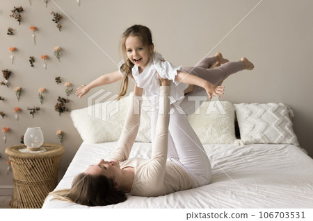 Cheerful excited little girl playing airplane flight, keeping balance Cheerful excited little girl playing airplane flight, keeping balance 106703531