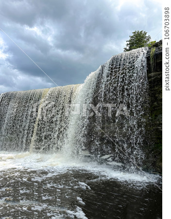 A beautiful big waterfall in Estonia on a clear sunny day 106703898