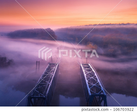 Aerial view of railroad bridge in fog at sunrise in autumn Aerial view of railroad bridge in fog at sunrise in autumn 106703922