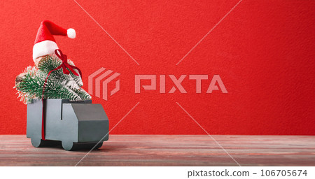 Christmas greeting card.grreen car carry pine tree with presents ribbon on red background table 106705674