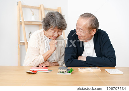 Senior couple real estate house model money 106707584
