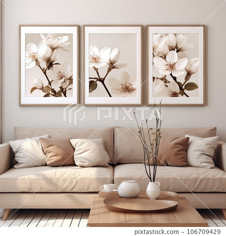 two white flowers on the wall above a beige couch in a coffee table and vase are placed next to the sofa 106709429