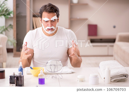 Young man shaving face at home Young man shaving face at home 106709703