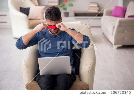 Blindfolded young male freelancer working from home 106710340