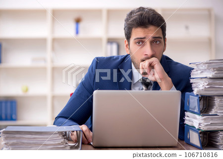 Young male employee and too much work in the office 106710816