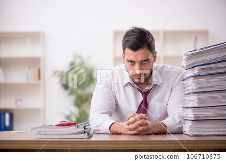 Young male employee and too much work in the office 106710875