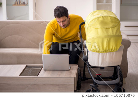 Young male contractor looking after baby at home 106710876