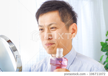 man using mouthwash man using mouthwash 106711072
