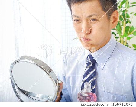 man using mouthwash man using mouthwash 106711073