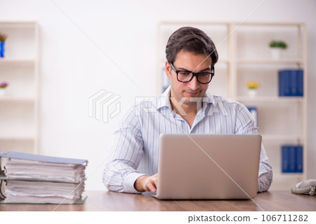 Young male employee and too much work in the office 106711282