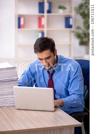 Young male employee and too much work in the office Young male employee and too much work in the office 106711811