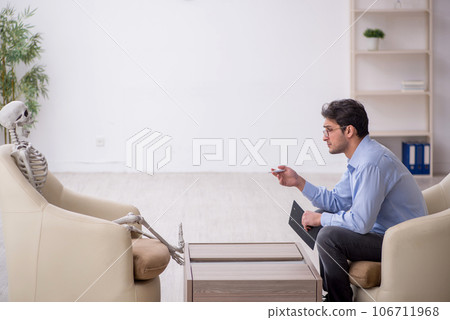 Young male psychologist meeting with skeleton 106711968