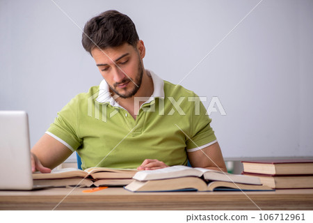 Young male student sitting in front of whiteboard 106712961
