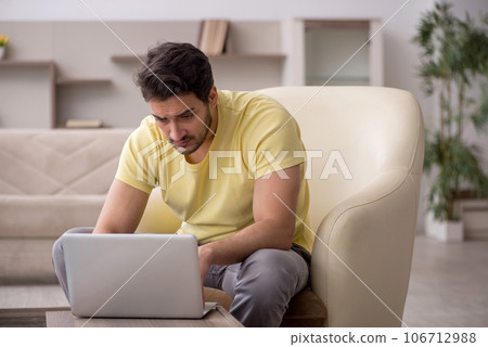 Young man working from home during pandemic 106712988
