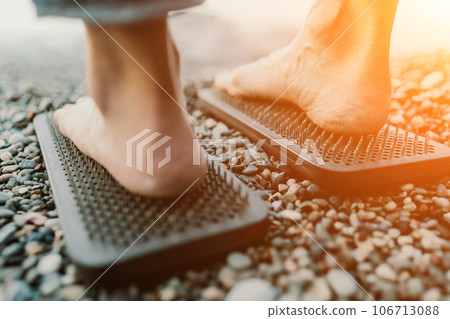 Sea Woman feet stepping on sadhu board during indian practice on the seashore. . Healthy lifestyle concept. tool for working out your inner state 106713088