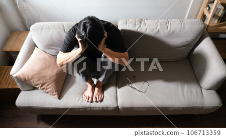 Man with mental health problem sitting on couch and use hands to covering ears from noise anything Man with mental health problem sitting on couch and use hands to covering ears from noise anything 106713359