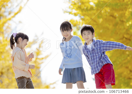 Elementary school students playing in a park with autumn leaves 106713466