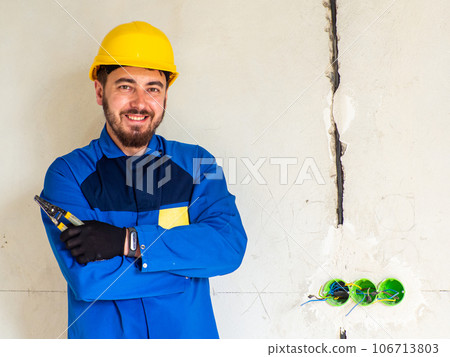 Portrait of worker or engineer in blue work clothes and yellow safety helmet Portrait of worker or engineer in blue work clothes and yellow safety helmet 106713803