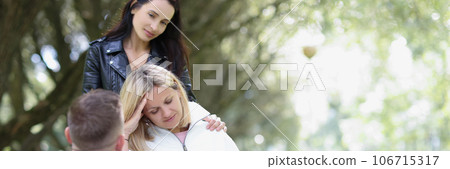 Man and woman support their disabled friend in wheelchair while walking in the park. Man and woman support their disabled friend in wheelchair while walking in the park. 106715317