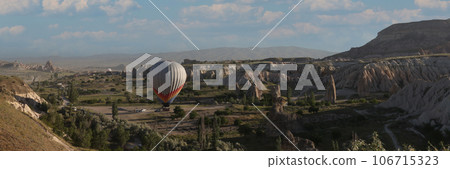 One hot air balloon over fairy chimneys and valley in Cappadocia, Turkey. One hot air balloon over fairy chimneys and valley in Cappadocia, Turkey. 106715323