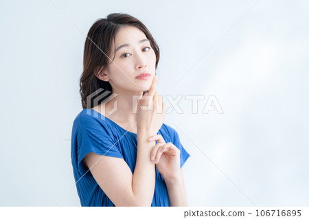 在陽光透過樹葉的白色背景下做護膚的年輕女性 在陽光透過樹葉的白色背景下做護膚的年輕女性 106716895