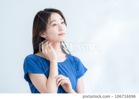 在陽光透過樹葉的白色背景下做護膚的年輕女性 在陽光透過樹葉的白色背景下做護膚的年輕女性 106716896