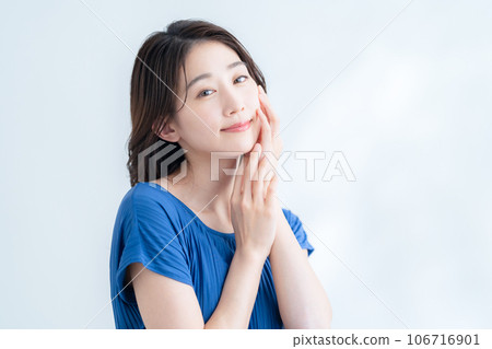 在陽光透過樹葉的白色背景下做護膚的年輕女性 在陽光透過樹葉的白色背景下做護膚的年輕女性 106716901
