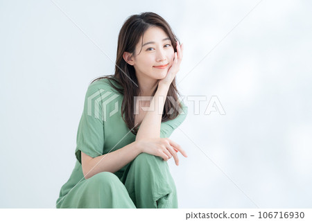 在陽光透過樹葉的白色背景下做護膚的年輕女性 106716930