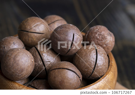 Unpeeled macadamia nuts on a wooden table Unpeeled macadamia nuts on a wooden table 106717267