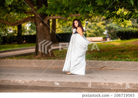 Woman city blanket. Morning in the big city. A blonde woman in a white blanket is enjoying in the city center. Photographed for social media 106719565