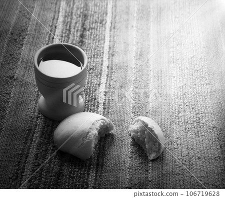 A bowl of wine and bread on the table. Communion symbols 106719628