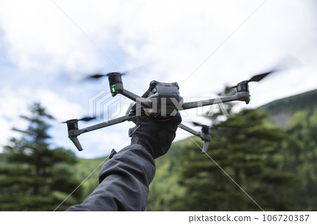 Flying drone in high altitude mountains Flying drone in high altitude mountains 106720387