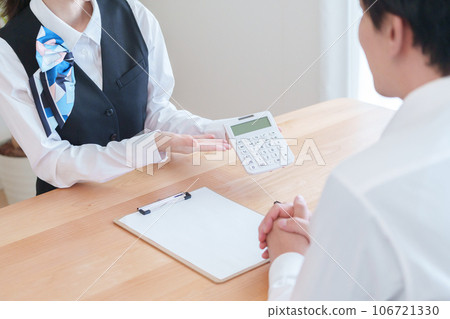 Reception staff explaining prices 106721330