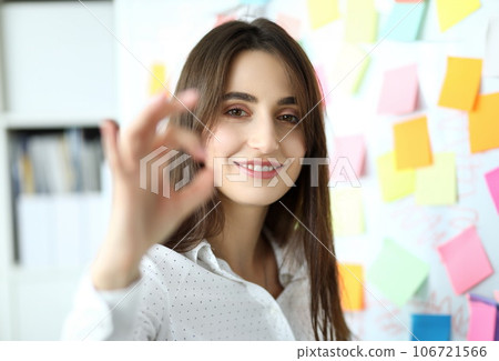 Cheerful female clerk showing all right symbol with her fingers Cheerful female clerk showing all right symbol with her fingers 106721566