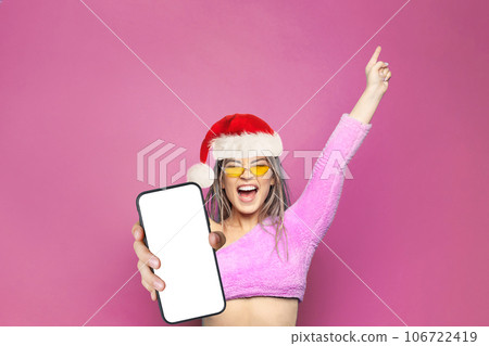 Christmas portrait of Happy excited woman Santa holding smartphone with white empty screen display Christmas portrait of Happy excited woman Santa holding smartphone with white empty screen display 106722419
