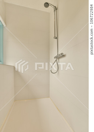 a bathroom with white tiles on the walls and shower head mounted to the wall next to the bathtub is blue 106722984