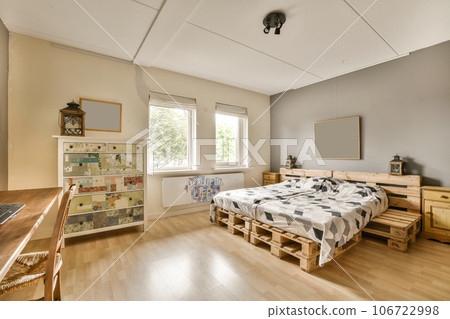 a bedroom with wood flooring and white walls, including a bed made out of wooden pallets on the wall a bedroom with wood flooring and white walls, including a bed made out of wooden pallets on the wall 106722998