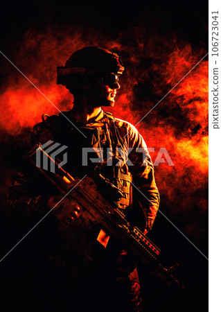 Backlit silhouette of special forces marine on fire explosion background. Battle, bombs exploding, smoke billows 106723041