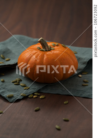 Orange pumpkin on linen napkin on wood table for seasonal background 106723092