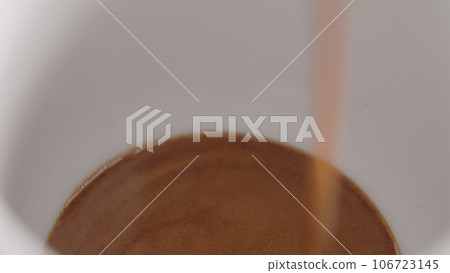 espresso pour into white cup closeup espresso pour into white cup closeup 106723145