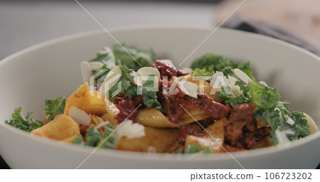 Pasta salad with sun dried tomatoes, kale and almond flakes 106723202