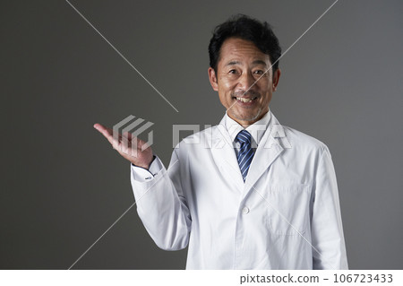 中年醫生手掌指向左側，黑色背景 106723433
