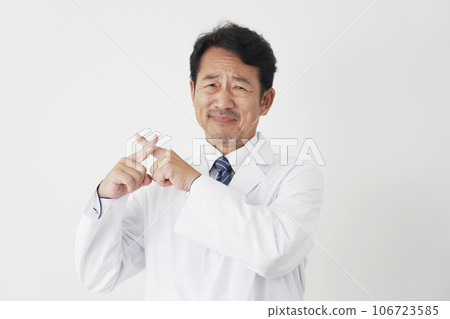Middle-aged doctor making a mark with his finger, white background 106723585