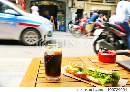 Vietnamese coffee and banh mi on a street corner in Hanoi 106724064