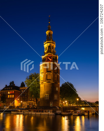 Montelbaan tower, Amsterdam, Netherlands. Evening cityscape. Dark sky and city lights. Montelbaan tower, Amsterdam, Netherlands. Evening cityscape. Dark sky and city lights. 106724207