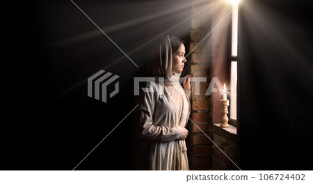 Young girl at the old wooden window 106724402