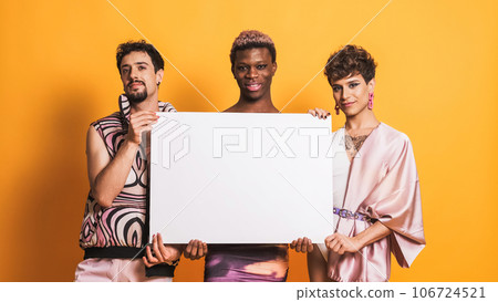 Multiracial group of transgender men holding a white panel on yellow 106724521