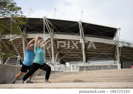 Asian senior couples wear sports outfit and warming up muscles before exercise at outdoor in the morning. Happy elderly outdoor lifestyle concept, Full length of active happy elderly family couple Asian senior couples wear sports outfit and warming up muscles before exercise at outdoor in the morning. Happy elderly outdoor lifestyle concept, Full length of active happy elderly family couple 106725293