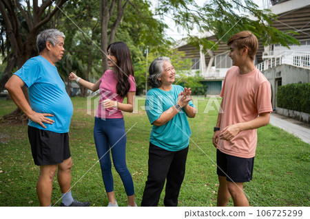 Healthy family group instructors workout in fresh air, and they rest and stand together after morning exercises in park. Outdoor activities, healthy lifestyle, strong bodies, fit figures, health care. 106725299